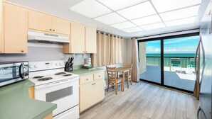 Una cocina moderna con una isla grande, comedor y balcón con vistas.