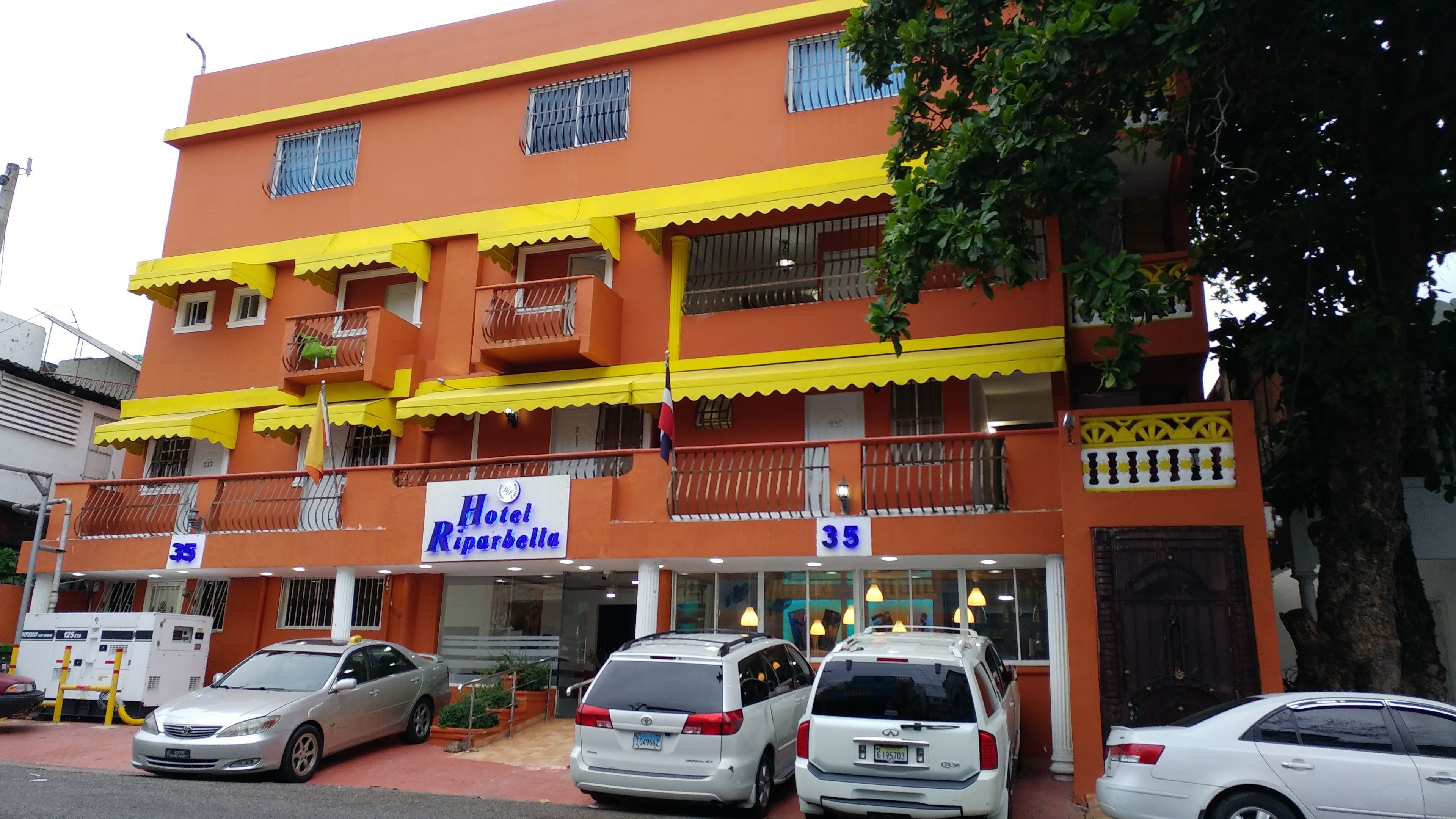 Un hotel de diversos pisos amb balcons i un rètol que diu "Hotel Riparbella".