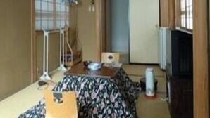 Ein traditioneller japanischer Raum mit Tatami-Böden, einem niedrigen Tisch und Schiebetüren.