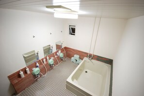 Een badkamer met een groot bad, een wastafel met spiegel en een toilet.
