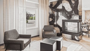 Una sala de estar moderna con un sofá, sillones, una mesa de centro y una televisión.