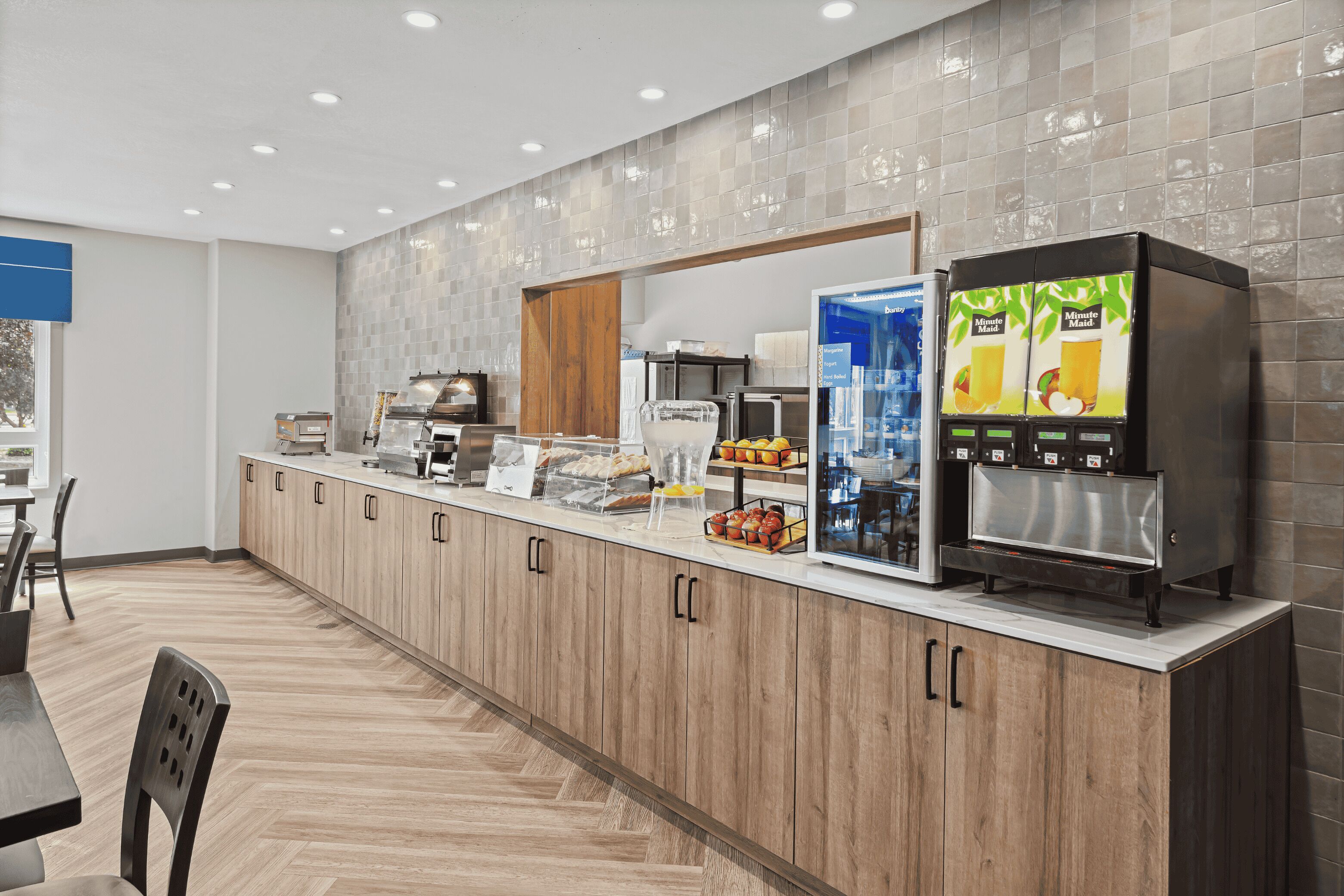 Una cocina moderna con una encimera larga, una cafetera y un refrigerador.