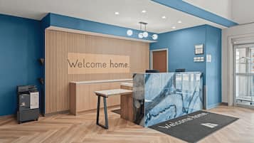 A reception area with a 'Welcome home' sign, a reception desk, a computer, and a printer.