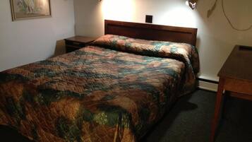A standard hotel room with a bed, bedside tables, and a small desk.