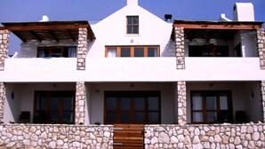 Un bâtiment à deux étages, avec des murs en pierre et une porte en bois.