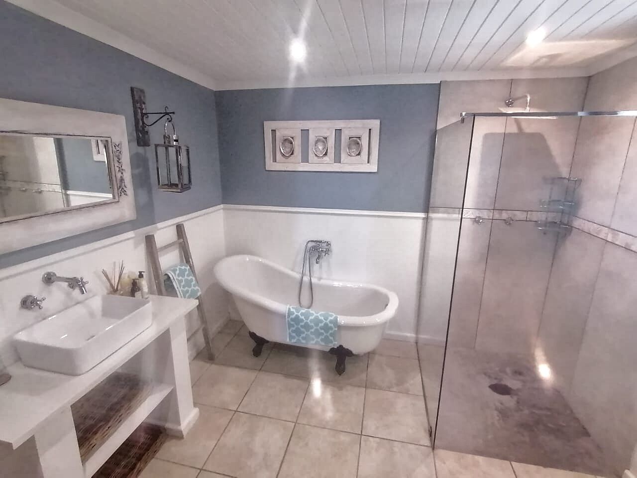 A bathroom with a freestanding bathtub, a sink, and a glass-enclosed shower.