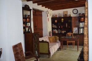 Une chambre à l’ancienne, avec un lit, des meubles en bois et une bibliothèque remplie de livres et d’objets décoratifs.