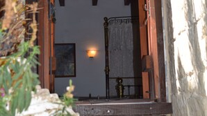 A stone building with a wooden door and a small balcony. - Lasa Heights (Lasa)