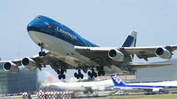 A large commercial airplane with multiple engines and a blue and white livery, taxiing on a runway.