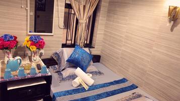 A neatly arranged bedroom with a bed, bedside table, and a mirror.