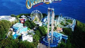 An aerial view of Ocean Park Hong Kong, featuring a large Ferris wheel, roller coasters, and various amusement rides. - Day And Night Hotel - Hostel (Kowloon)