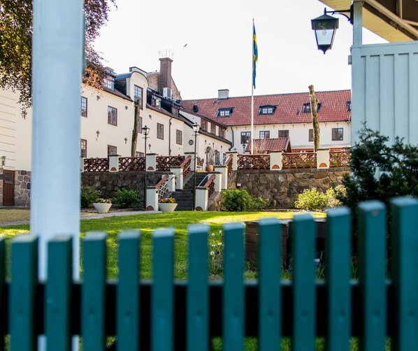 A traditional European building with a stone staircase leading to a gated entrance. - Värdshuset Hwitan (Falkenberg)