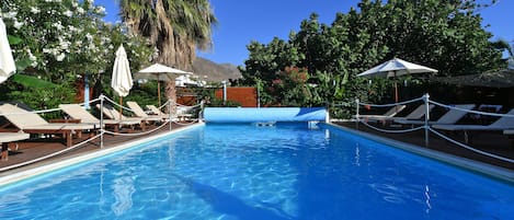 Piscine extérieure, parasols de plage, chaises longues