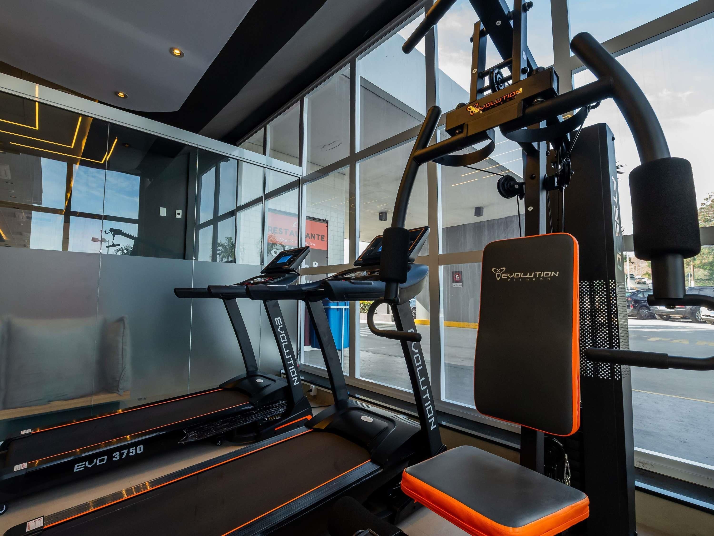 A gym with treadmills, a bench, and exercise equipment.