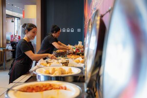Montaje de bufé con diversos alimentos y utensilios para servir.
