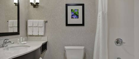 A modern bathroom with a sink, toilet, and shower.