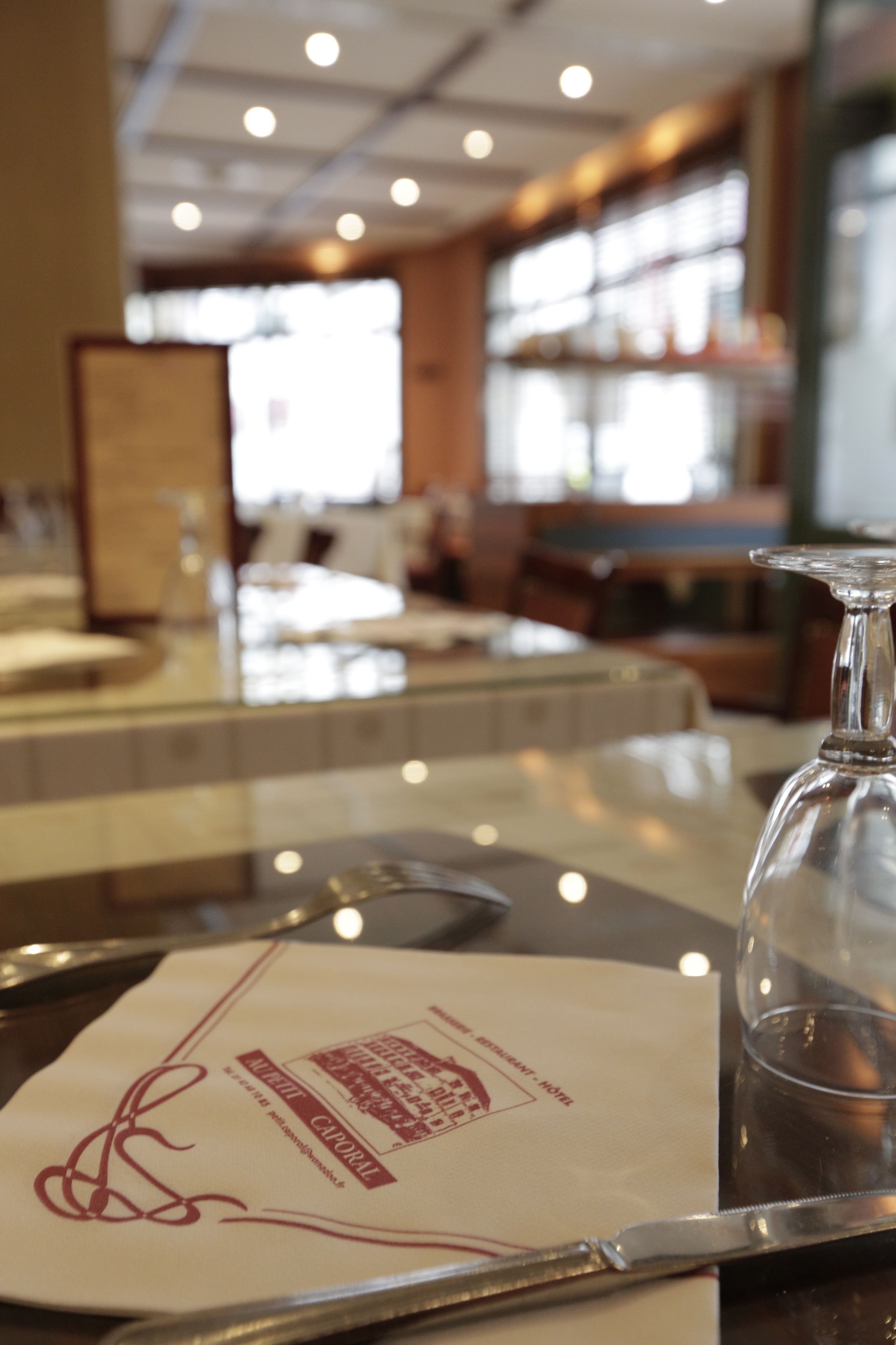 A restaurant setting with a menu on a table, a glass pitcher, and a dining area in the background.