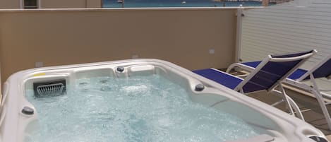 A hot tub with a view of the sea and a beach.