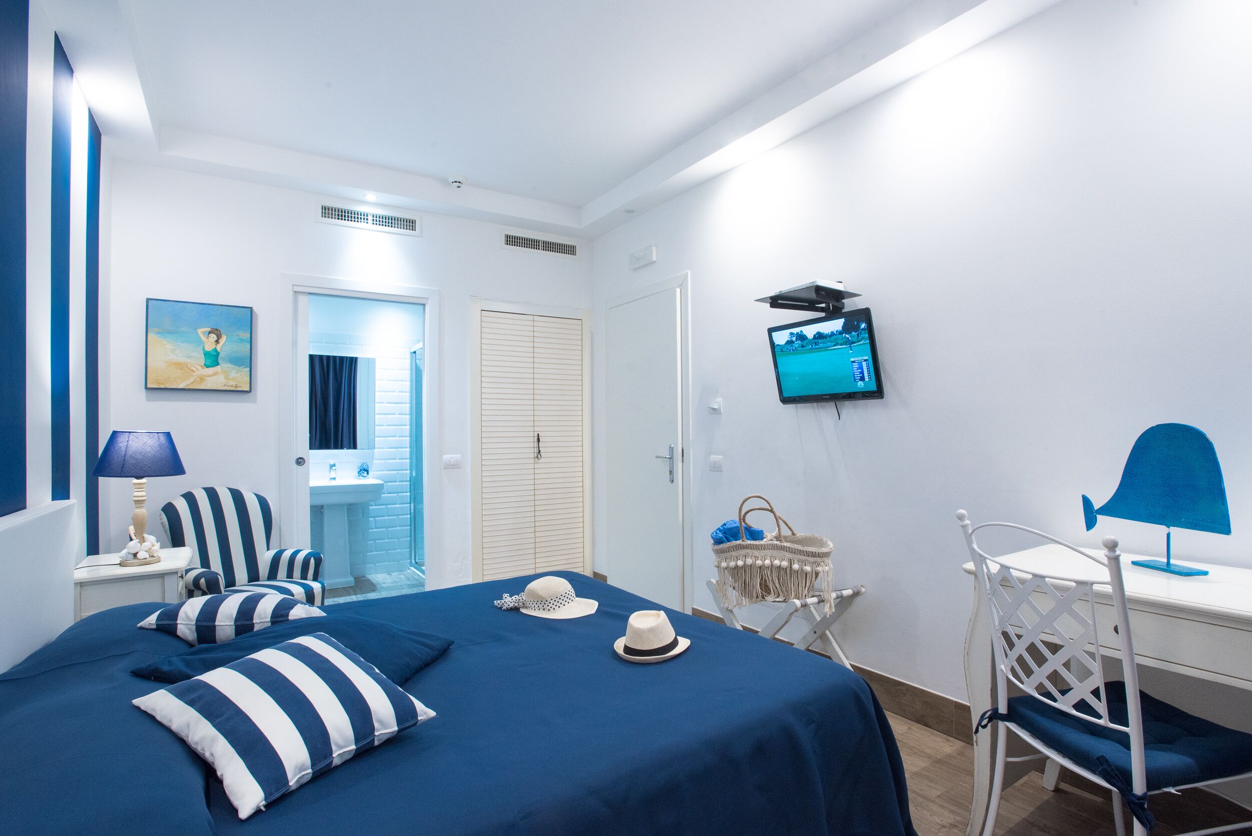 A room with a bed, a desk, a TV, and a chair.