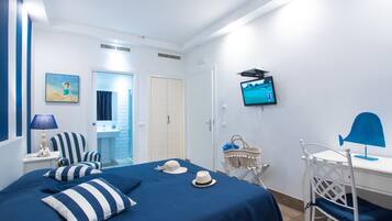 A room with a bed, a desk, a TV, and a chair.
