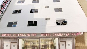 A hotel with a sign reading "HOTEL CHANAKYA INN." It has multiple windows and a glass entrance. - Airport Hotel Chanakya (New Delhi)