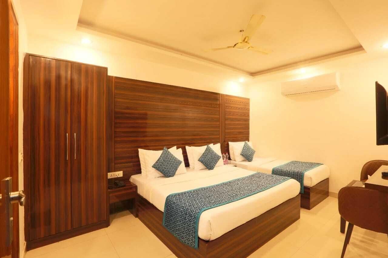 Una camera d'albergo con un letto grande, due comodini, un armadio e una ventola a soffitto.