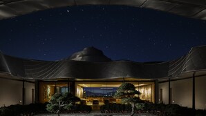 A modern building with a unique architectural design, featuring a large, curved roof structure and a well-lit interior.