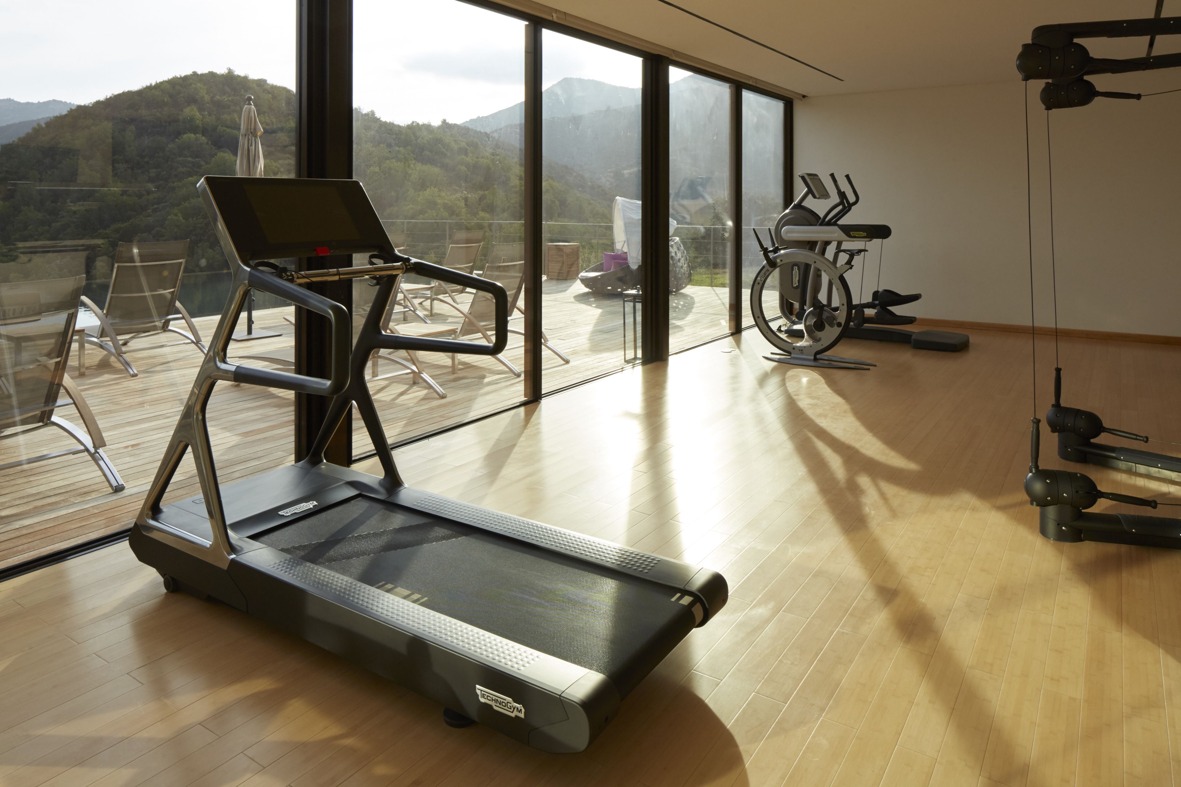 Une salle de sport équipée de tapis de course, de vélos d’appartement et d’autres appareils d’exercice.
