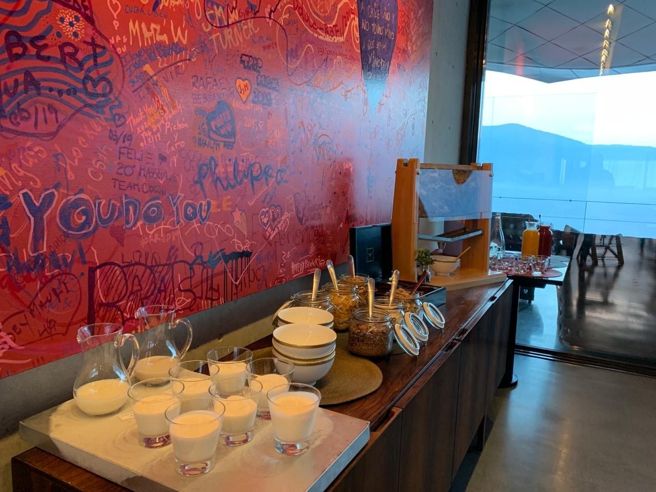 Een ontbijtbuffet met diverse gerechten en een muur vol graffiti.