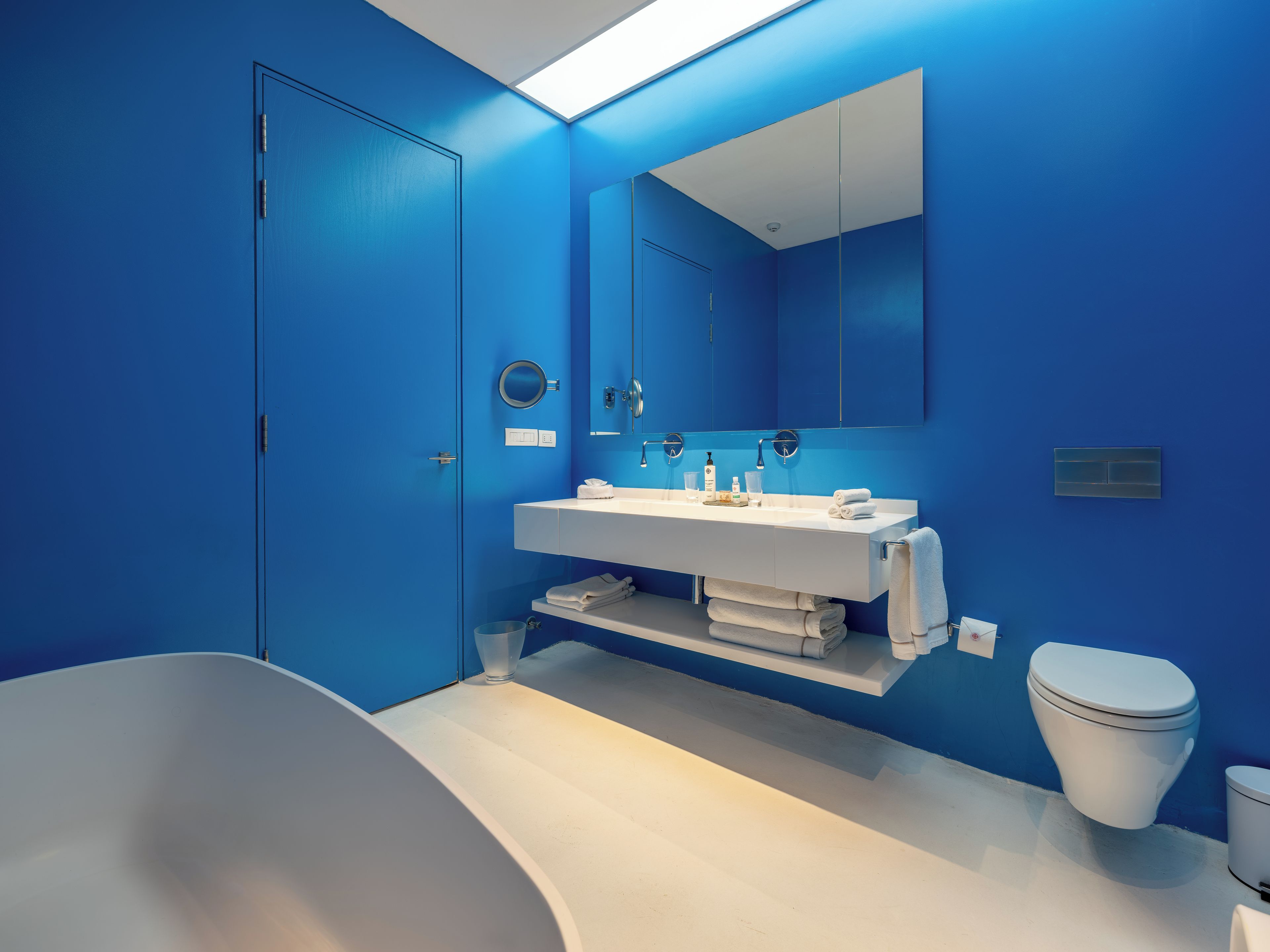 A modern bathroom with a white bathtub, a white sink, and a toilet.