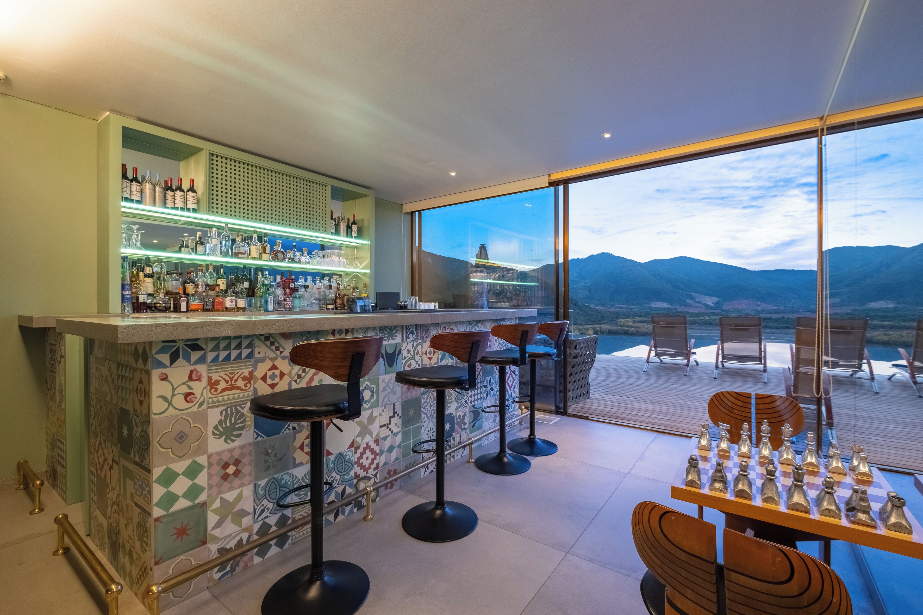 Zona de bar con vistas a las montañas a través de amplios ventanales.