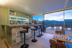 A bar area with a view of mountains through large windows. - Vik Chile (San Vicente)