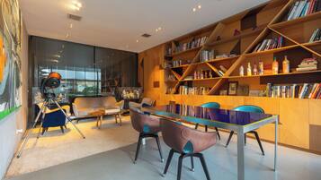 Una biblioteca moderna con estanterías, un telescopio y asientos cómodos.