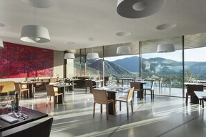 A modern restaurant with large windows offering a mountain view.
