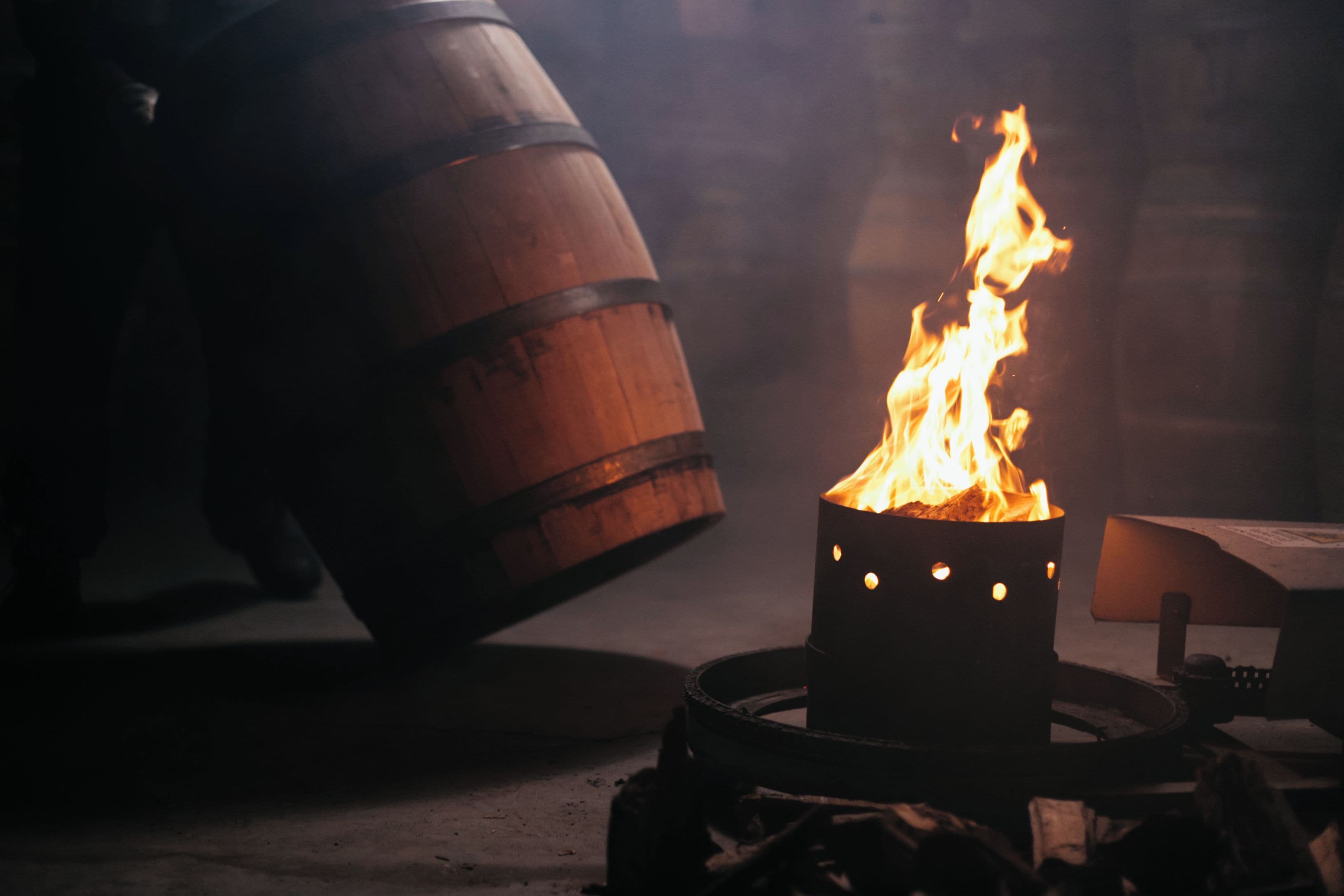 A barrel with a fire burning inside it, placed on a flat surface.