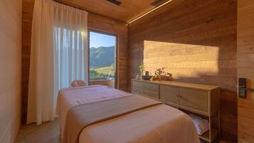 Une chambre à coucher avec un lit, une table de chevet et une vue sur un paysage par la fenêtre.