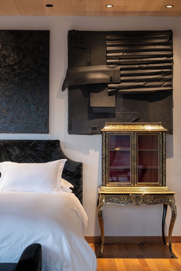 A bedroom with a bed, a decorative cabinet, and a modern abstract painting on the wall. - Vik Chile (San Vicente)