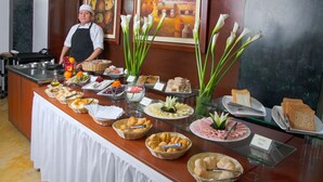 A buffet with various food items and a chef standing behind it. - Miraflores Colon Hotel (Lima)