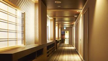 Un pasillo de hotel con un diseño de pared a cuadros, una barra de madera y una alfombra a rayas.