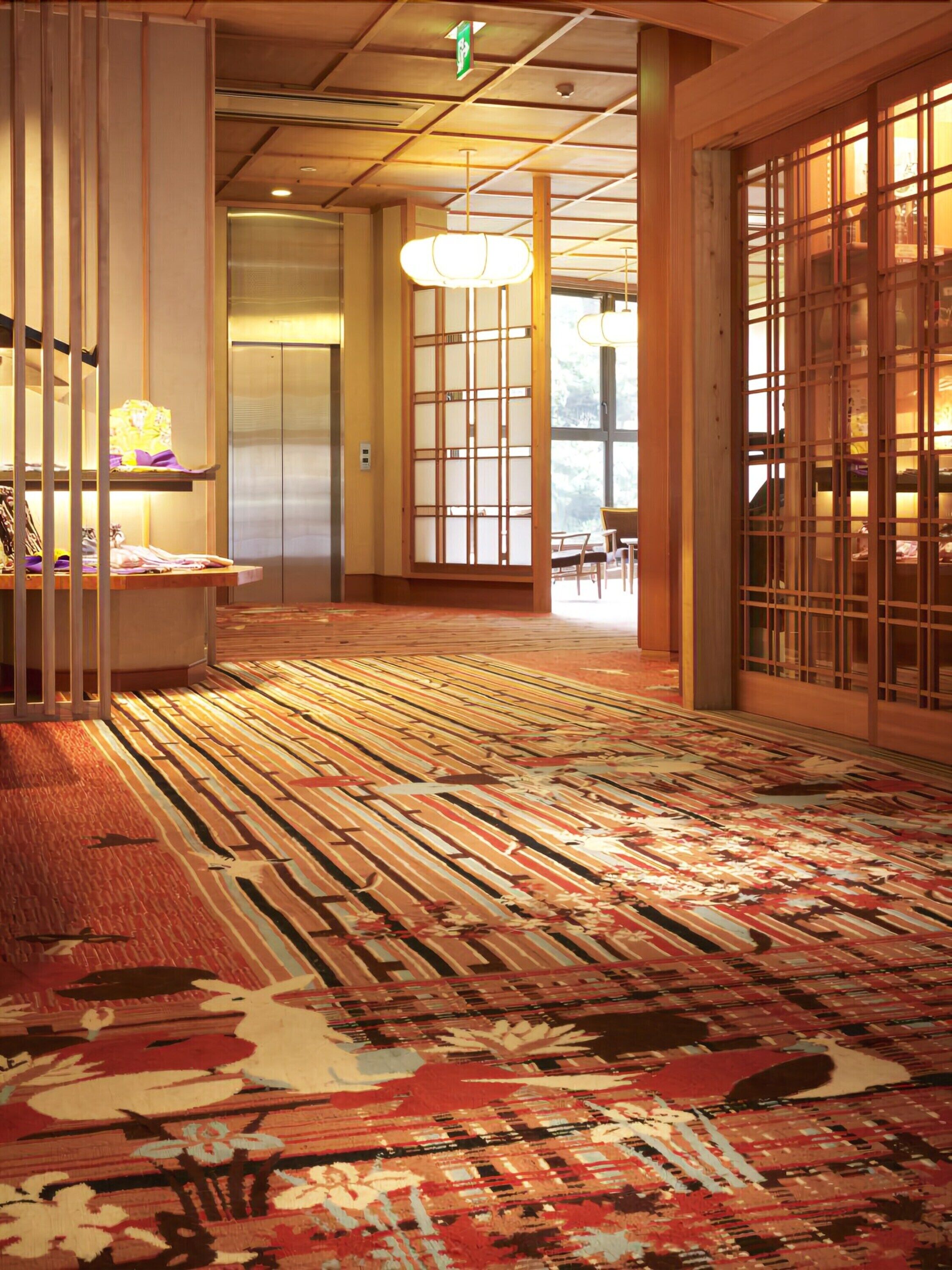 A traditional Japanese-style room with tatami flooring, a shoji screen door, and a hanging light fixture.
