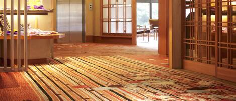 A traditional Japanese-style room with tatami flooring, a shoji screen door, and a hanging light fixture.