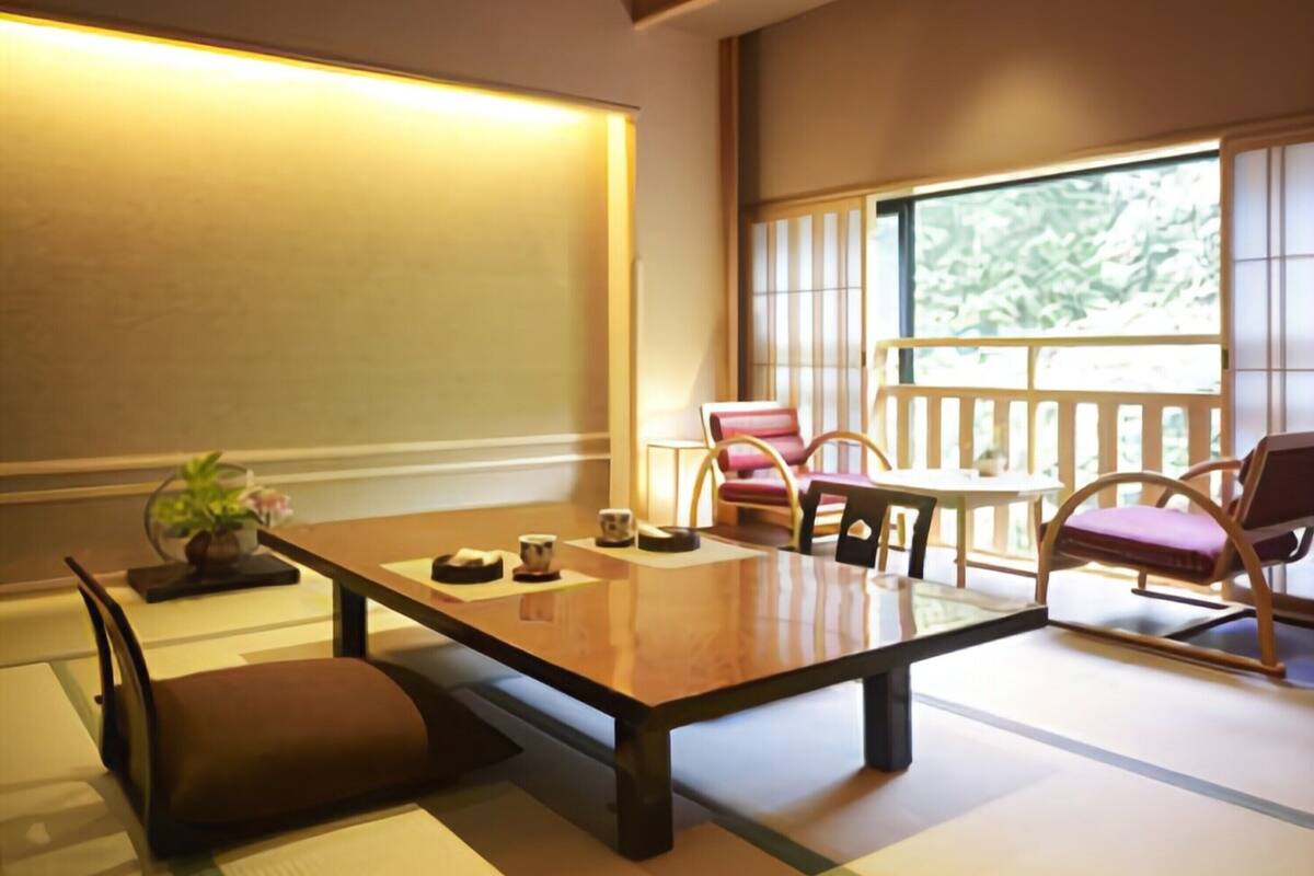 A traditional Japanese-style room with tatami flooring, a low table, and seating arrangements.