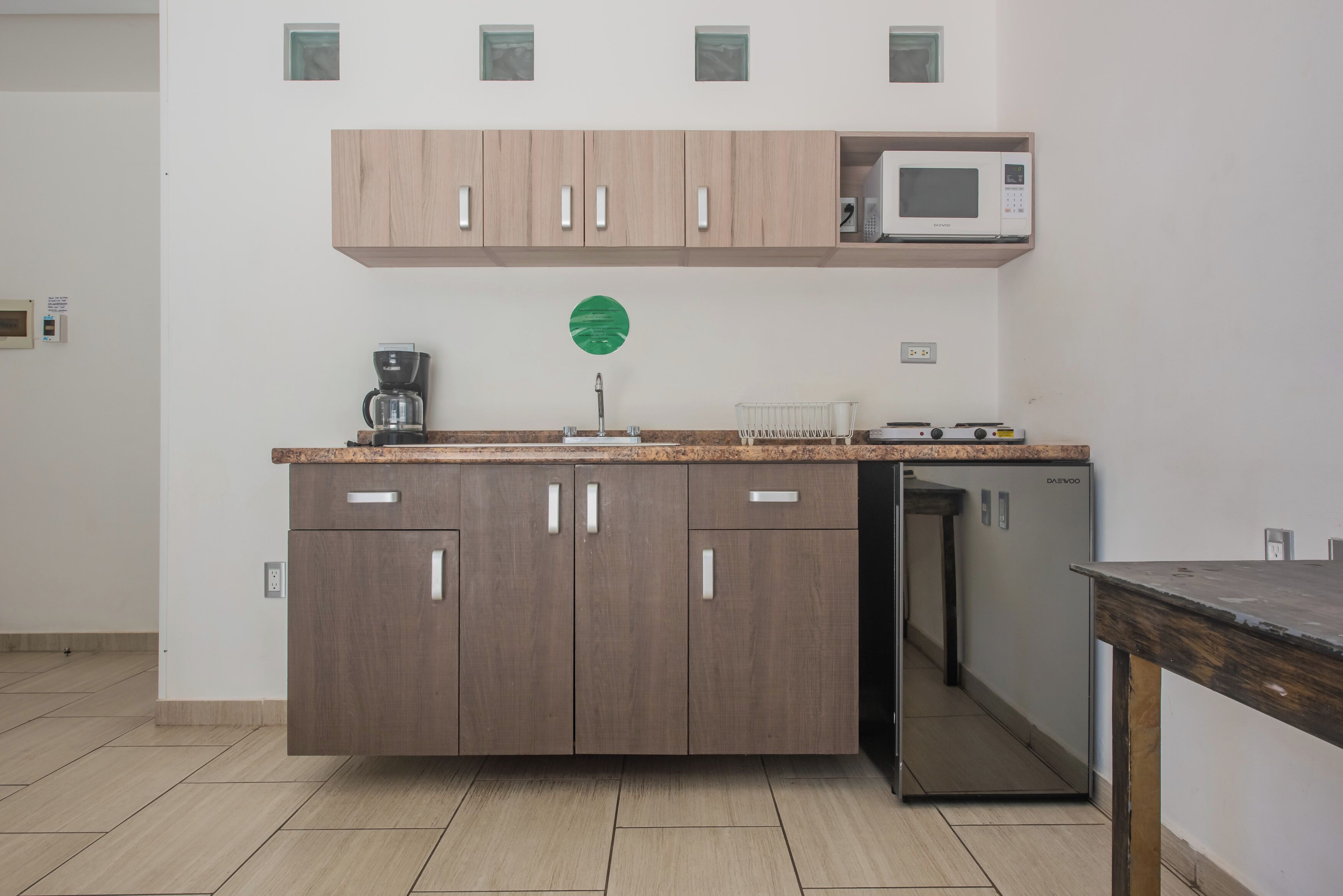 A modern kitchen with wooden cabinets, a microwave, a coffee maker, and a dishwasher.