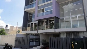 A multi-story building with a modern architectural design, featuring large windows and balconies. - IRIS Studios & Apartments (Playa del Carmen)