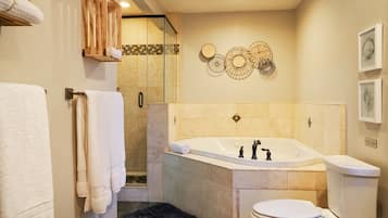 A modern bathroom with a freestanding bathtub, a glass-enclosed shower, and a toilet.