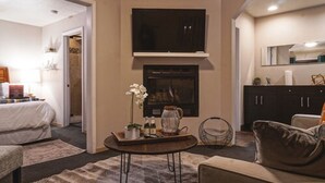 Una sala de estar moderna con un sofá, una mesa de centro, una chimenea y un televisor.