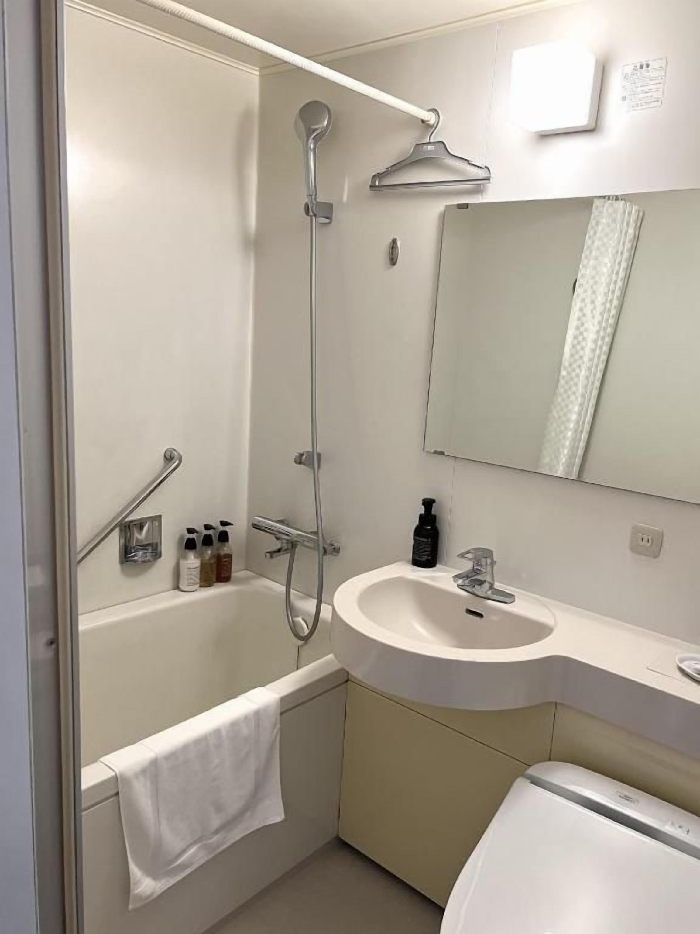 A bathroom with a bathtub, a shower, a sink, and a toilet.