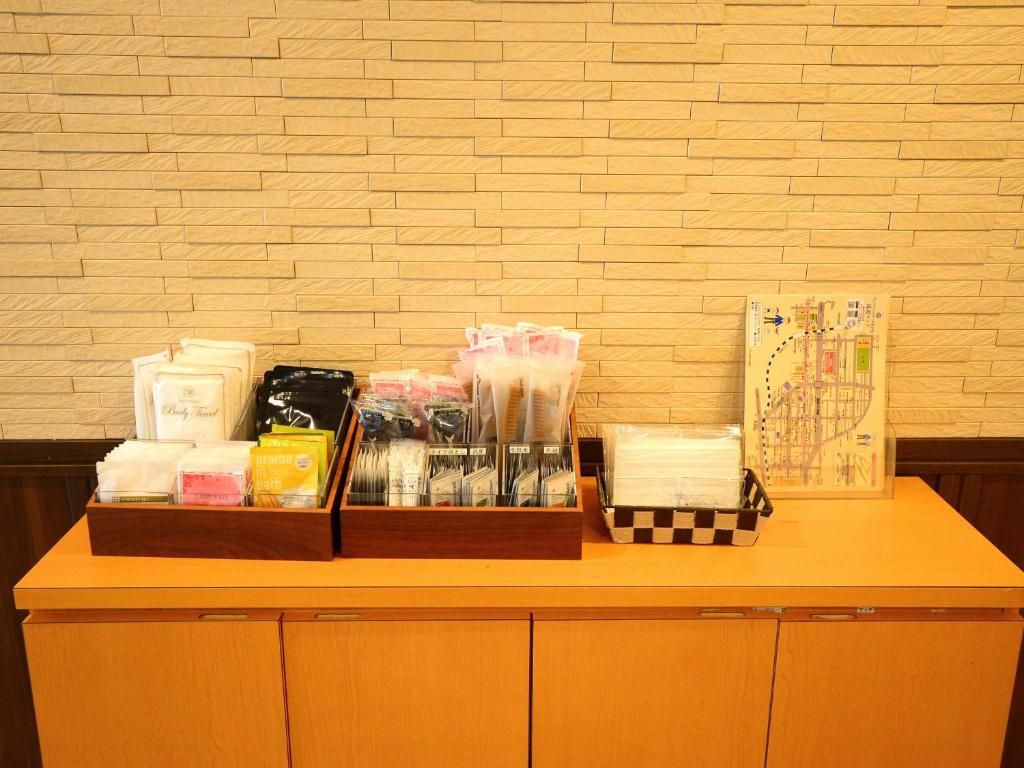 A reception desk with a wooden counter, a brick wall background, and various items including a map, brochures, and a basket.