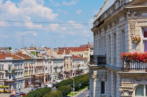 Vista callejera con edificios históricos, un tranvía y cielo despejado.