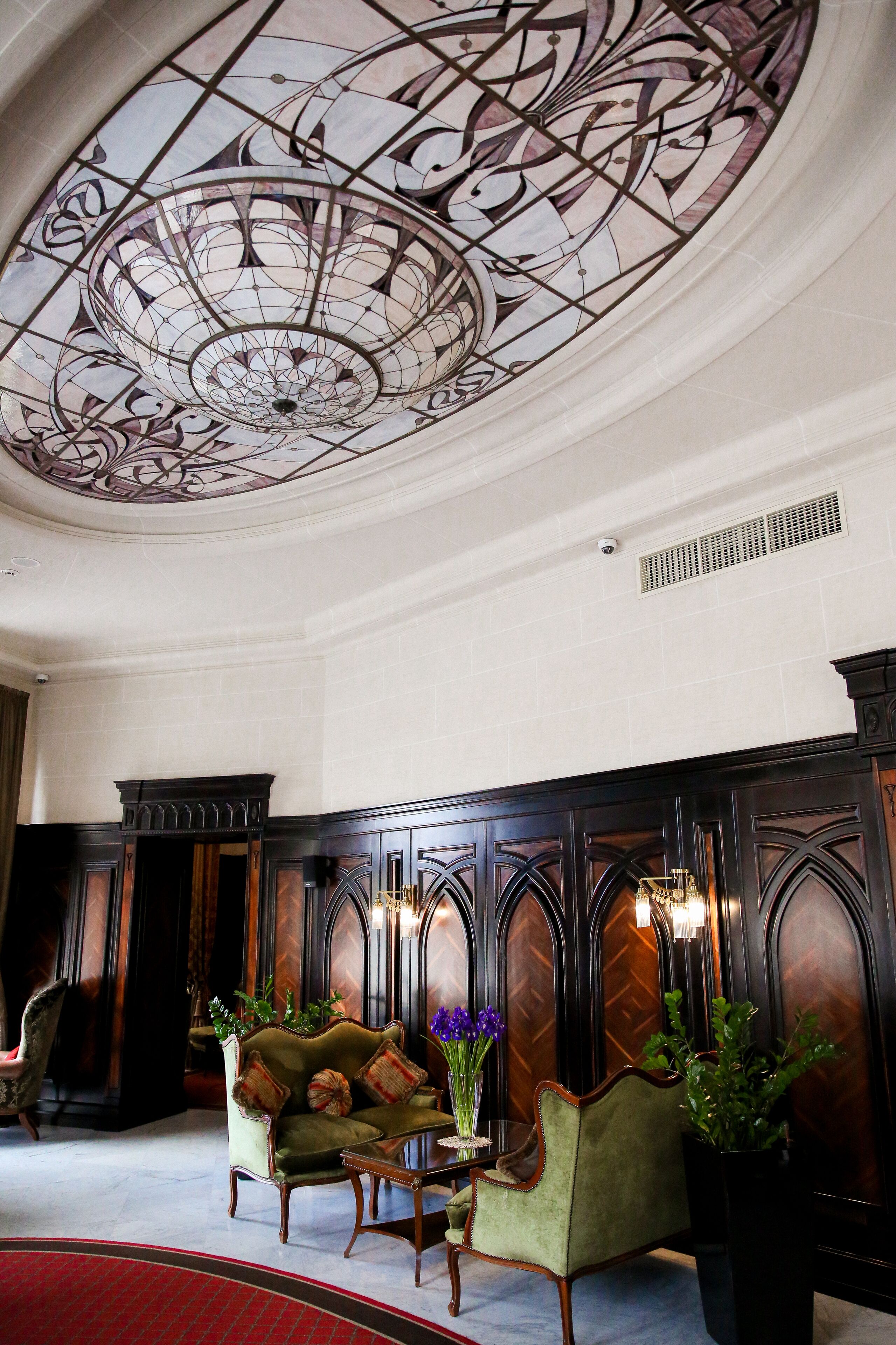 Una sala imponente con un techo grande y ricamente decorado y paneles de madera oscura.